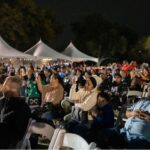 An Audience faces the stage at the River of Lights events.