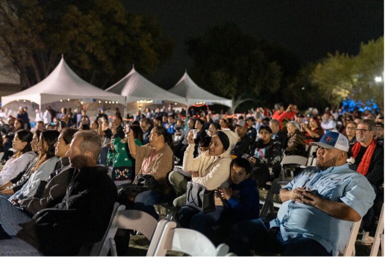 An Audience faces the stage at the River of Lights events.