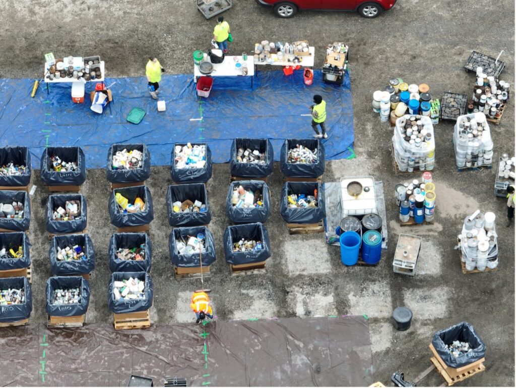 Drone photo showing overhead bins filled with paint cans as they are collected during a Household Hazardous Waste Collection Event. 