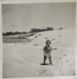 A small child stands in a concrete area