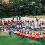 People sitting on island beach with kayaks and paddles