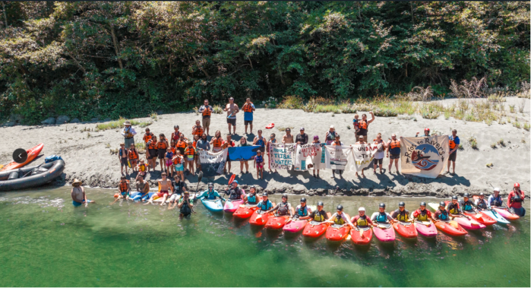 People sitting on island beach with kayaks and paddles