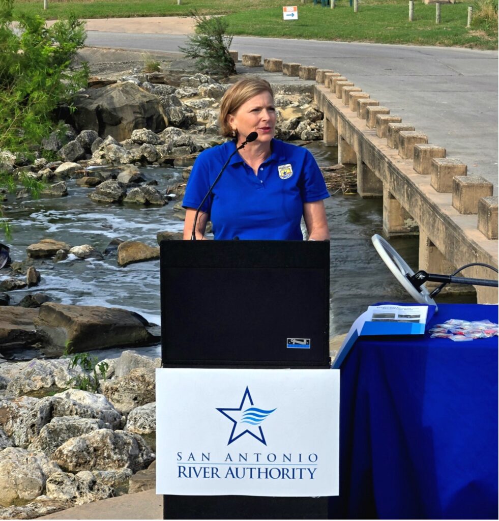 A woman stands behind a podium.