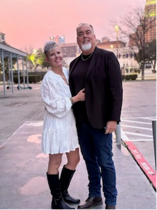 A couple stands together posed in downtown San Antonio.