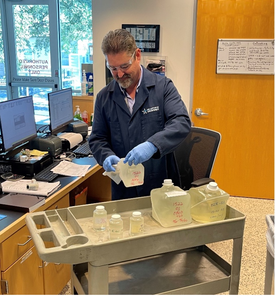 A River Authority scientist fills sample bottles with river water.