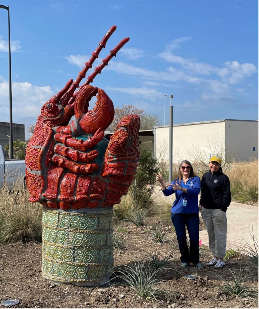 Crawdad sculpture next to Patrice Melancon and Liza Barratachea