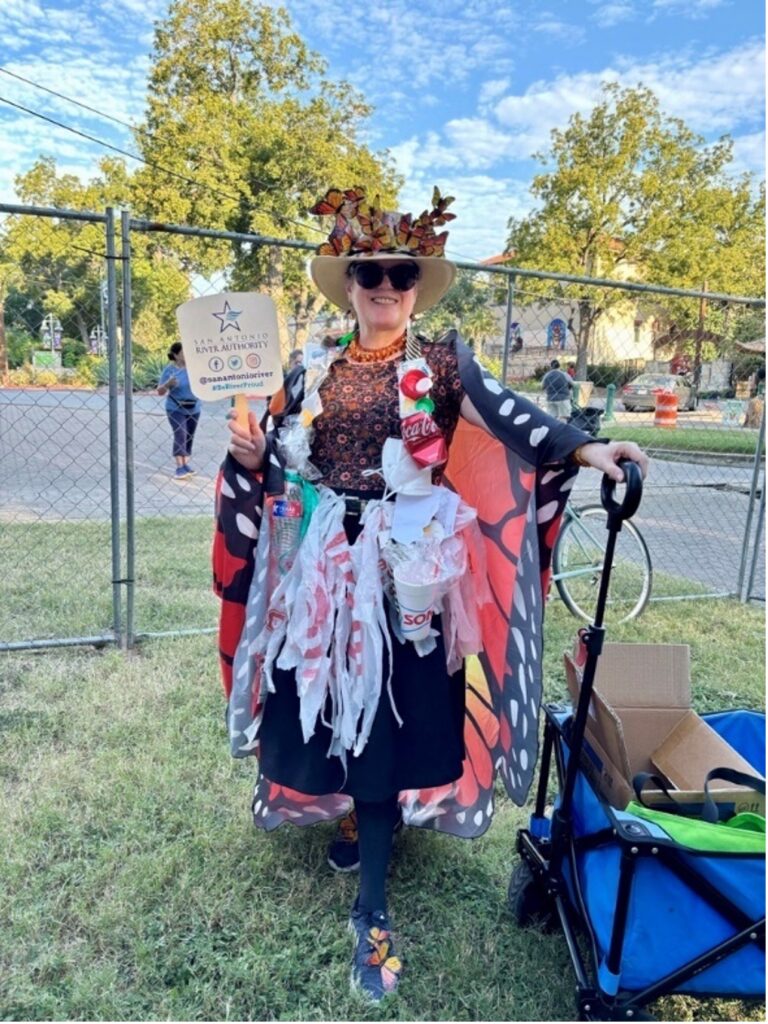 A woman dressed as a "litterbug" made of trash