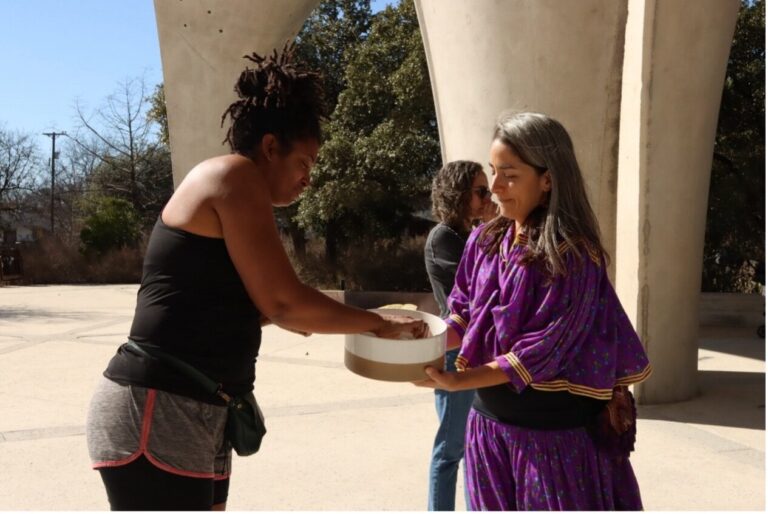 Two women gather around a bowl