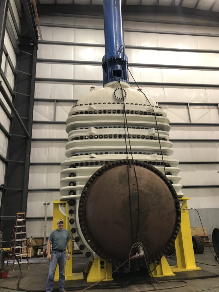 Steve Metzler stands next to the worlds largest gate valve in the world.